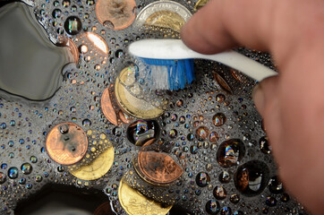 Black Euro coins being washed, suggesting the term "whitewash of black money"
