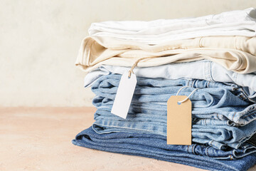 Stack of jeans pants on table
