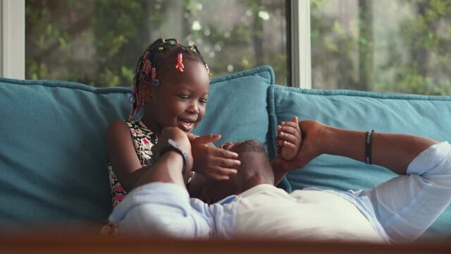 Cheerful african american father and daughter playing in living room, Cheerful girl kissing her dad, Happiness family concepts