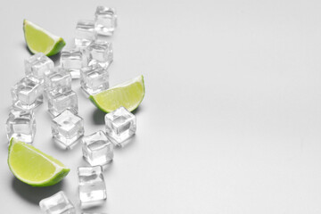 Ice cubes and lime on grey background