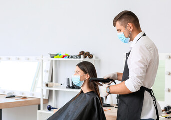 Male hairdresser working with client in salon during coronavirus epidemic