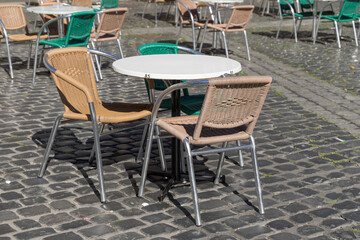 empty tables and chairs outdoors in front of a restaurant