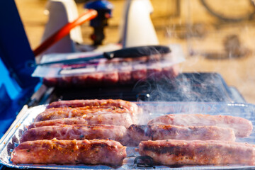 Sausages meat grilling on gas grill