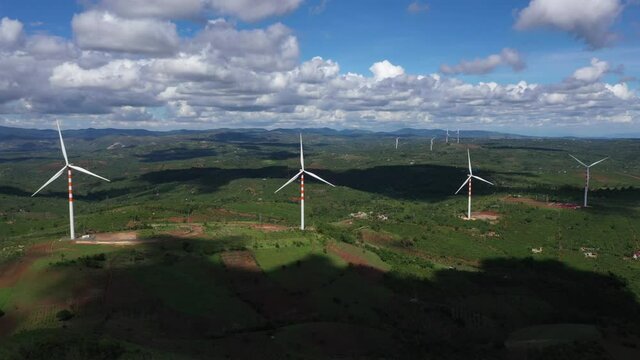 Aerial view of windmills farm for energy production on beautiful cloudy sky at highland. Wind power turbines generating clean renewable energy for sustainable development, Ea H'leo, Dak Lak, Vietnam 