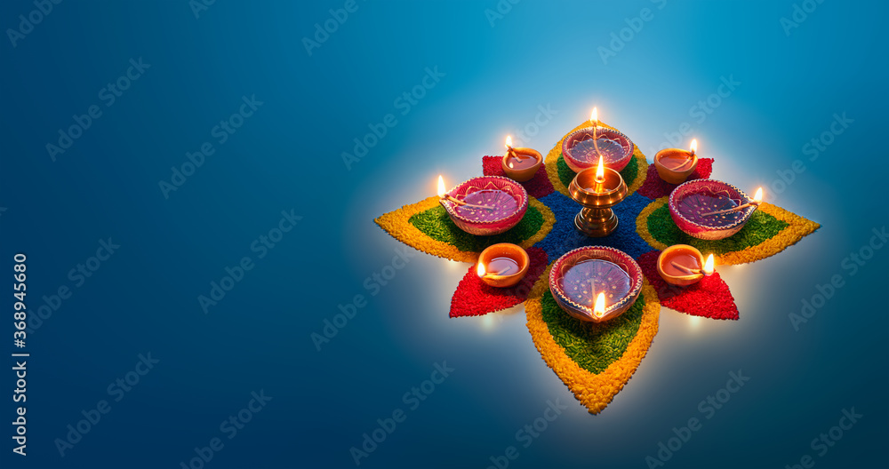 Wall mural happy diwali, diya lamps lit on colorful rangoli