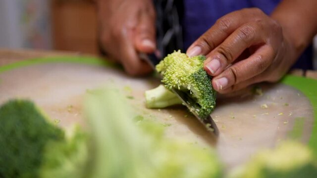 Cutting broccoli for a homemade stir fry meal - slow motion