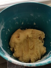 A close-up of dough in a green plastic bowl.