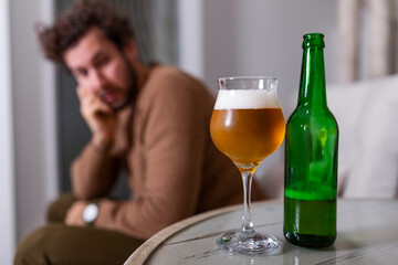 Depressed sad young addicted man feeling bad drinking beer alone at home, stressed frustrated lonely drinker alcoholic suffer from alcohol addiction having problem, alcoholism concept
