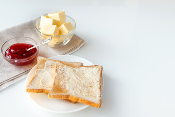 Toast bread, strawberry jam or marmalade and butter on table served for breakfast or brunch