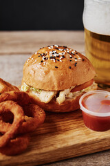 Different types of fastfood and snacks and glass of beer on the table. Unhealthy and junk food.
