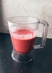 Home-made strawberry and raspberry milkshake in a blender bowl.