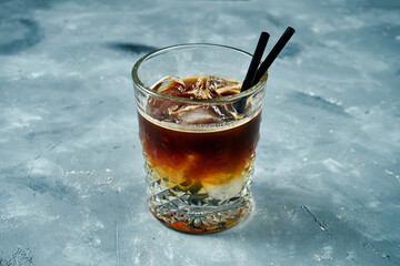 Espresso with ice. Cold bru in a beautiful glass on a concrete background