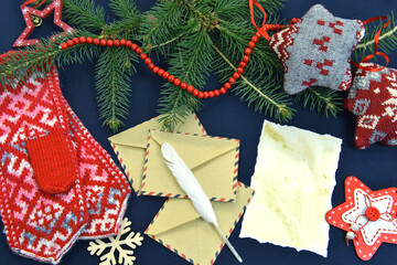 Still life with evergreen branch, envelope, quill and knitted mitts. Letter to Santa concept.