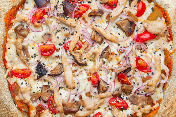 Pizza with chicken, mushrooms and tomatoes closeup