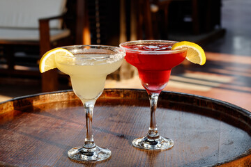 A glass of cocktail at the bar. Two sweet cocktails Cosmopolitan and Margarita in the pub. Mixed...