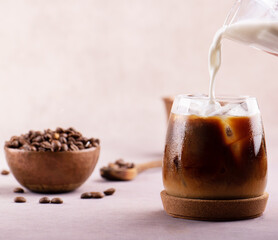 Milk pouring into the iced coffee