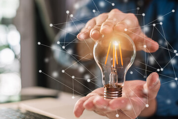 Businessman holding light bulbs, ideas of new ideas with innovative technology and creativity in...