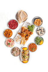 grilled chicken.  Partially sliced grilled chicken breast with black pepper and rock salt isolated on white. Grilled chicken kebab with red onions on a light table. Traditional turkish meal - selectio