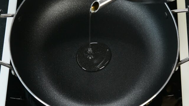 Pouring coconut oil in a frying pan.