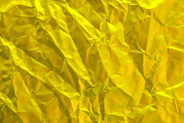 Gold foil texture background, pattern of yellow wrapping paper with crumpled and wavy.
