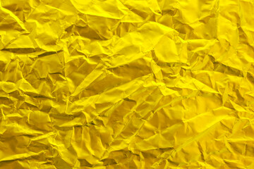 Gold foil texture background, pattern of yellow wrapping paper with crumpled and wavy.
