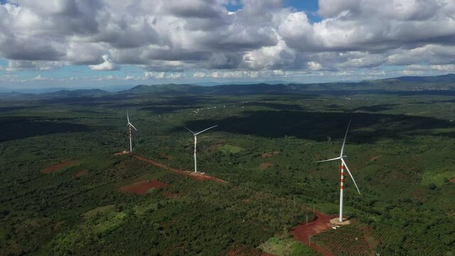 Aerial view of windmills farm for energy production on beautiful cloudy sky at highland. Wind power turbines generating clean renewable energy for sustainable development, Ea H'leo, Dak Lak, Vietnam 