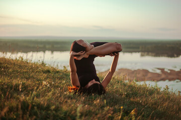 Yoga practice and meditation in nature in sunrise. Woman practicing near big river Kama.