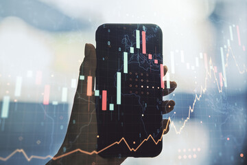 Multi exposure of abstract creative financial graph with world map and hand with phone on background, forex and investment concept