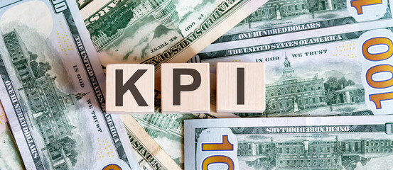 Concept words KPI on wooden blocks on a beautiful background from dollar bills.