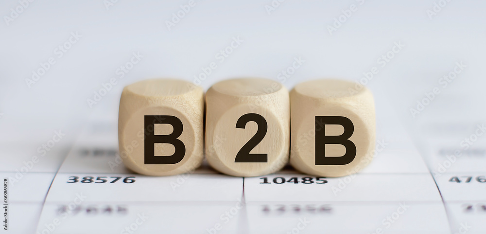 Aufkleber text b2b on a wooden cube blocks on chart background