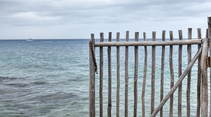 Wooden fence on the beach, Cozumel, Mexico. Blue seascape