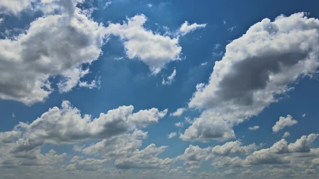 White beautiful fluffy clouds in the blue sky with timelapse rolling clouds