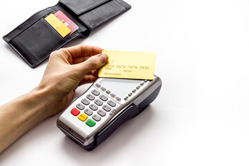 Payment by credit card. Hand hold card near terminal on white table copy space