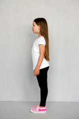 Fototapeta premium Cute young child with long hair in white t-shirt and black sweatpants