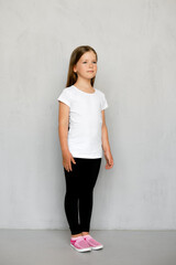 Cute young child with long hair in white t-shirt and black sweatpants