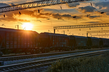 Fototapeta na wymiar railway and cars in a beautiful sunset, dramatic sky and sunlight