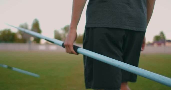 Close-up: Hand a Male athlete at the stadium takes a javelin for throwing and prepares to make a throw. Goes takes the spear. Training of a javelin thrower