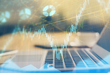 Forex market graph hologram and personal computer on background. Double exposure. Concept of investment.