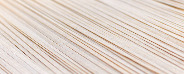 Brown soba noodles close up, top view. Asian cuisine, buckwheat pasta, raw, uncooked, natural, organic, vegetarian healthy food background. Striped surface. Banner with copy space.