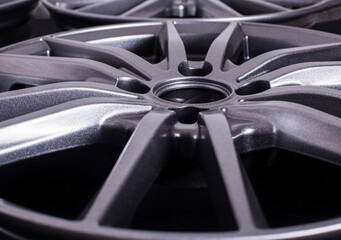 Modern automotive alloy wheel made of aluminum on a black background, industry. Designer fashion...