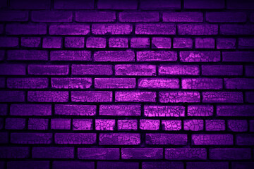 Neon light on an old brick wall. Purple grunge background. Lighting effect.