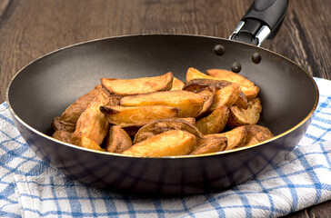 Frying pan with chips on a wooden table.