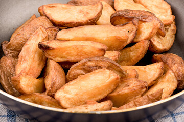 Macro shot. Frying pan with chips on a wooden table.