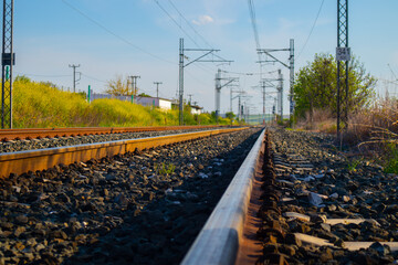 railroad tracks at blue sky and green field