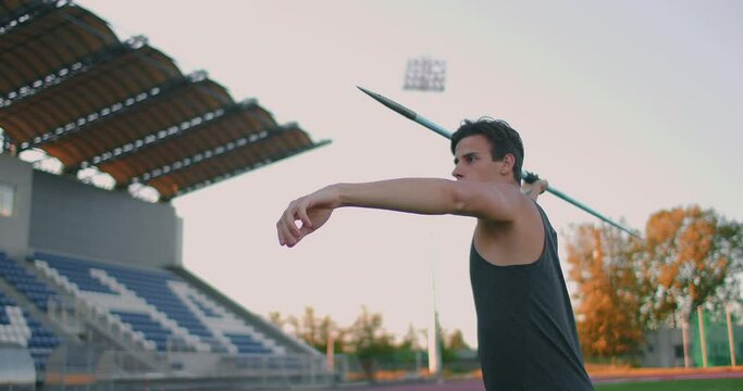 Javelin thrower before a throw. Concentration and exhalation. Excitement and fear before the throw. Confident look and run at the stadium of an athlete performing the javelin throw