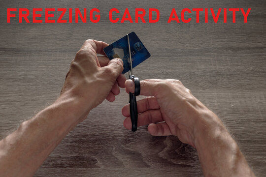 male hands with scissors cut the payment blue master card. concept of liquidation, destruction of deactivation, decommissioning with the inscription freezing card activity.