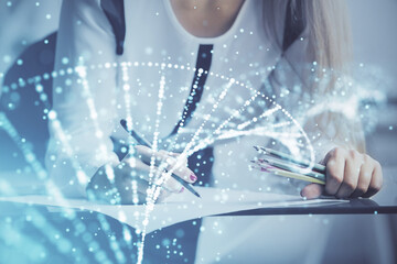 DNA theme hologram over woman's hands writing background. Concept of education. Double exposure