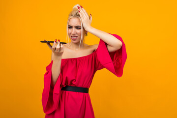 girl in a red dress holding her head thinking about talking on the phone n a yellow background
