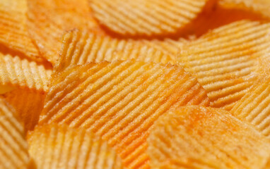 Background with yellow potato chips riffle. Close-up view. Natural product.