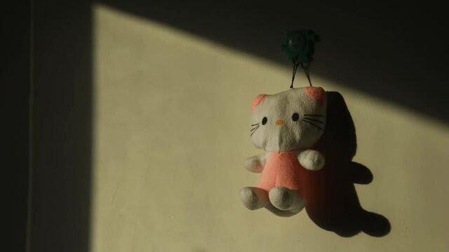 Light and shadow moving on the wall, close shot, sunlight through the window on the wall with a doll, time-lapse